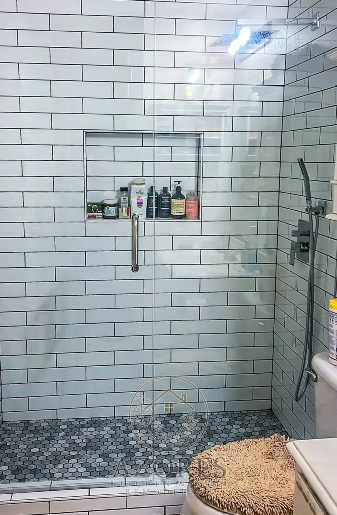 Remodeled walk-in shower with white subway tile and black fixtures