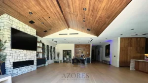 Spacious remodeled living room with vaulted wood ceiling and stone fireplace